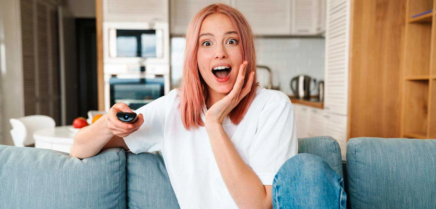 Mujer asustada viendo películas de ataques cibernéticos